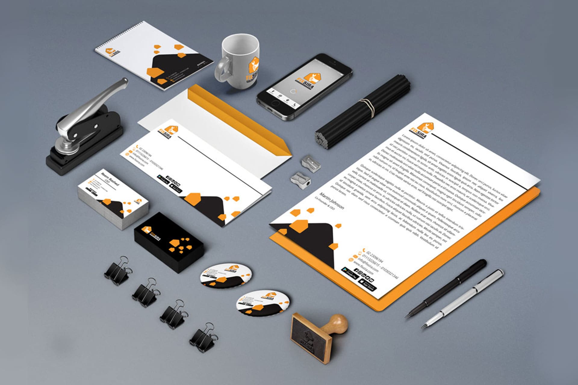 SIGA Corporate Identity Stationery Mockup: An organized flat lay of professional office supplies and branding materials, including letterheads, business cards, envelopes, a notebook, and a mug, all featuring the SIGA logo and a modern orange and black geometric design. Corporate branding and visual identity portfolio.