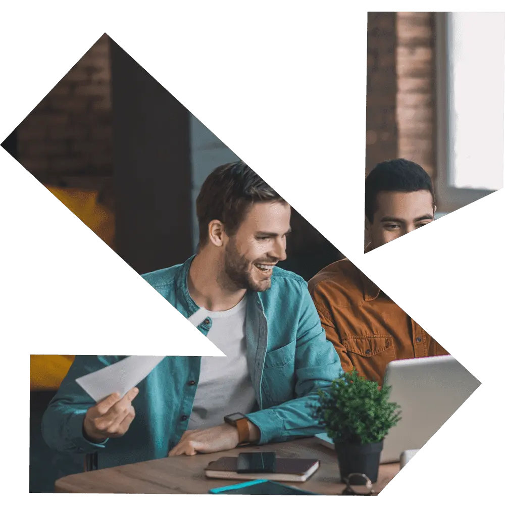 Cropped Business Consultation Meeting Graphic: A stylized, geometrically cropped image of two businessmen interacting over a laptop and notebooks at a cafe table. One man smiles, holding a document, symbolizing collaboration, business strategy, or client consulting in a dynamic, modern design presentation.